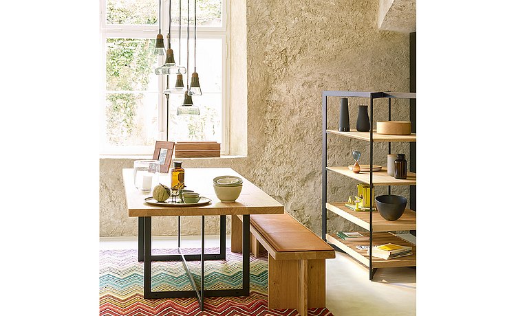 b Solitaire table and bench in front of open stone wall in Mediterranean house