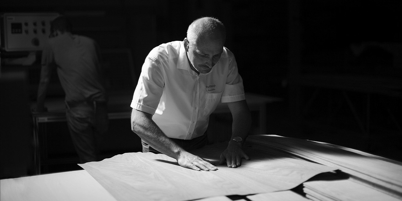 A veneer expert checks their material carefully