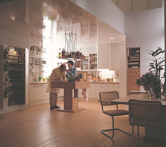 Open-plan kitchen as a new room concept with island and hanging element. New functional organization elements in the cabinets